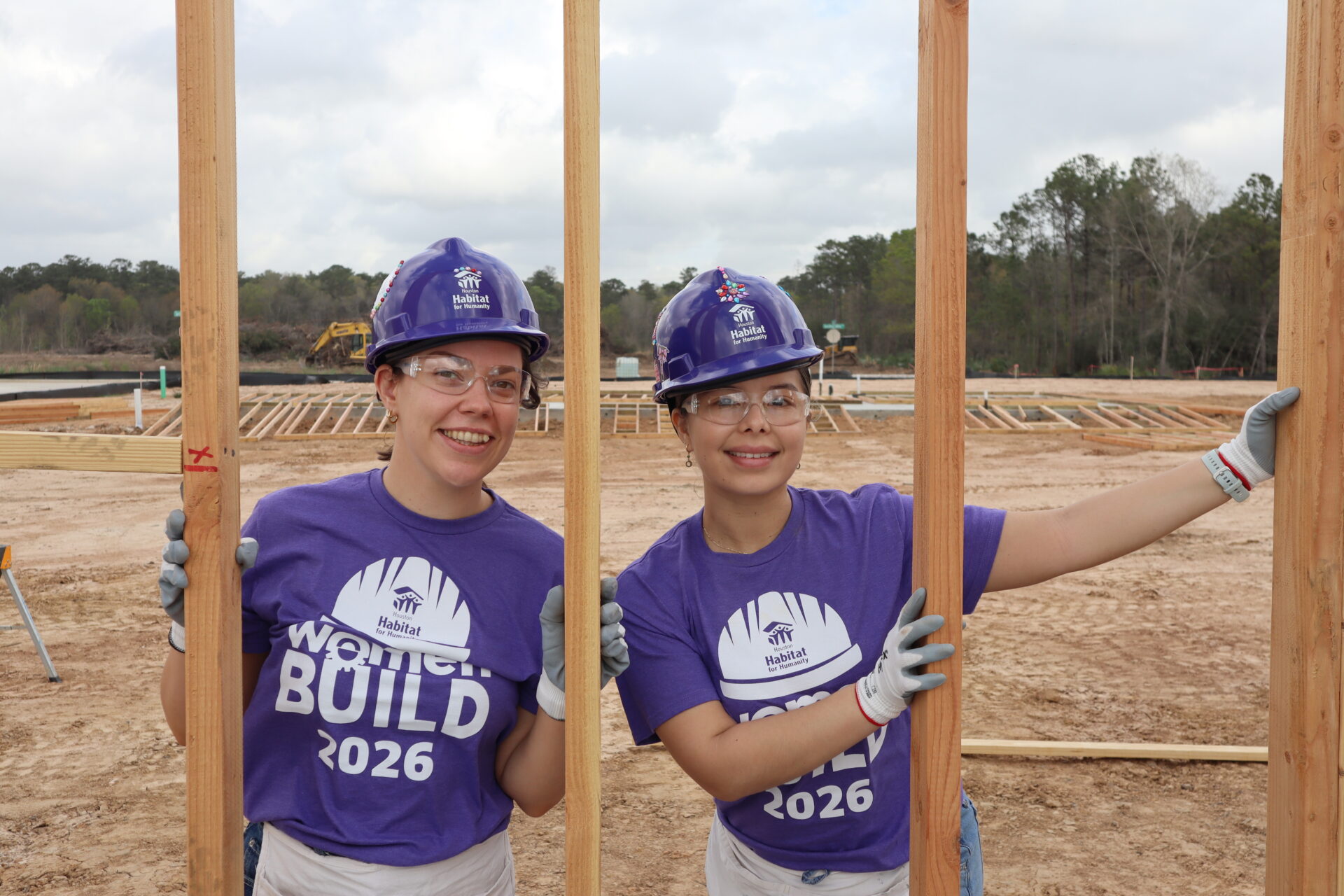 Gexa Volunteers in purple shirts and hard hats at women build