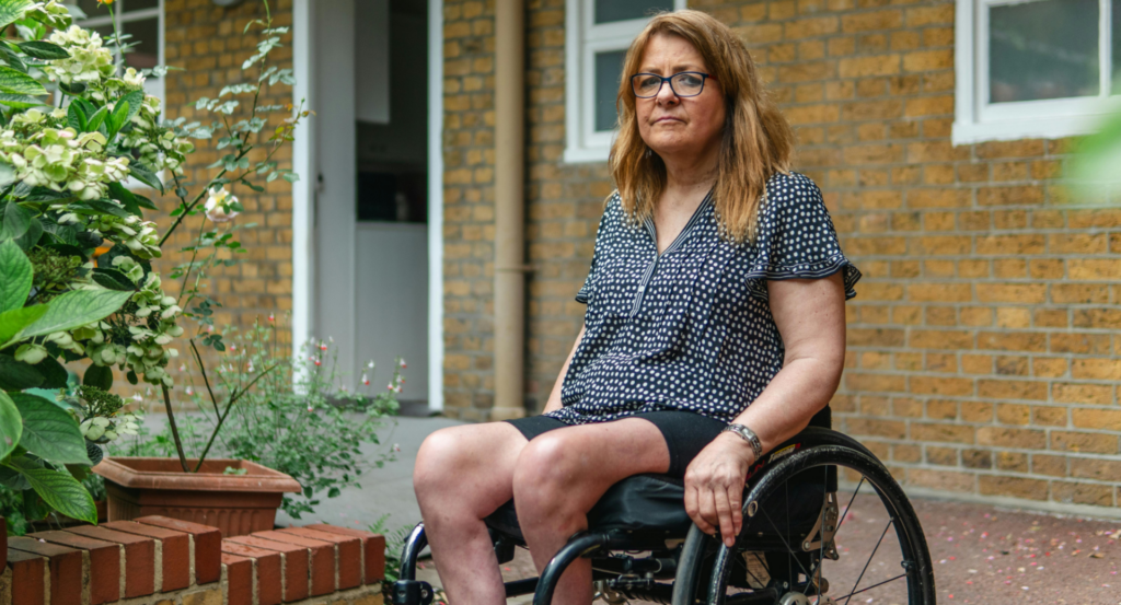 Woman sitting in a wheelchair outside of her home